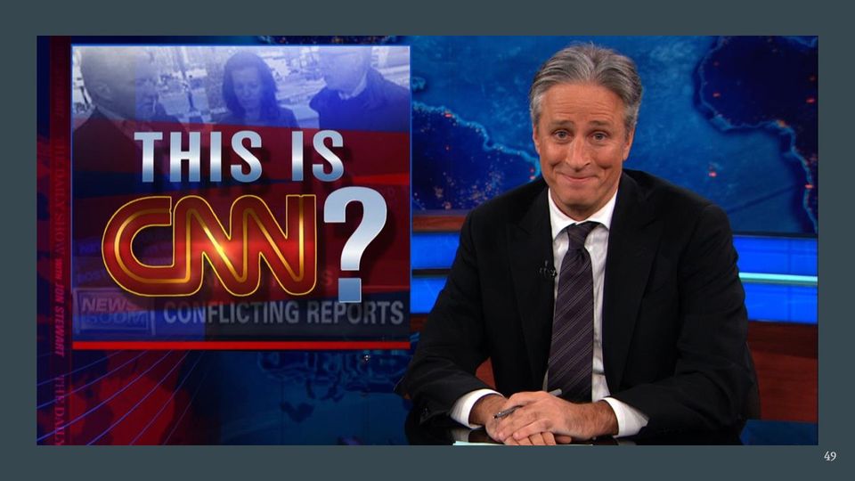 Television still: a smiling gray-haired man in a dark suit and tie at a news desk, beside an inset graphic reading THIS IS CNN?